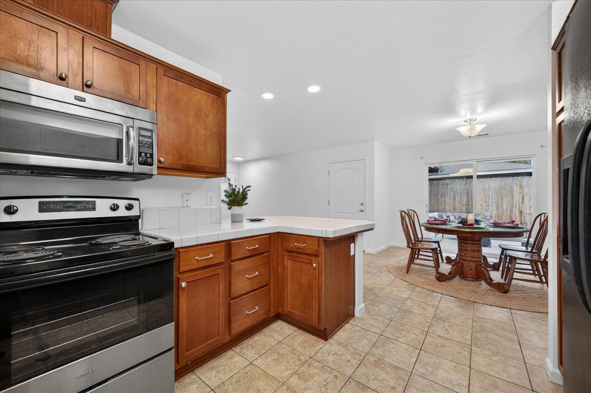 4776 East Rialto Avenue Fresno, CA 93726 - Photo 16 of 54 a kitchen with stainless steel appliances granite countertop a stove a sink and a microwave