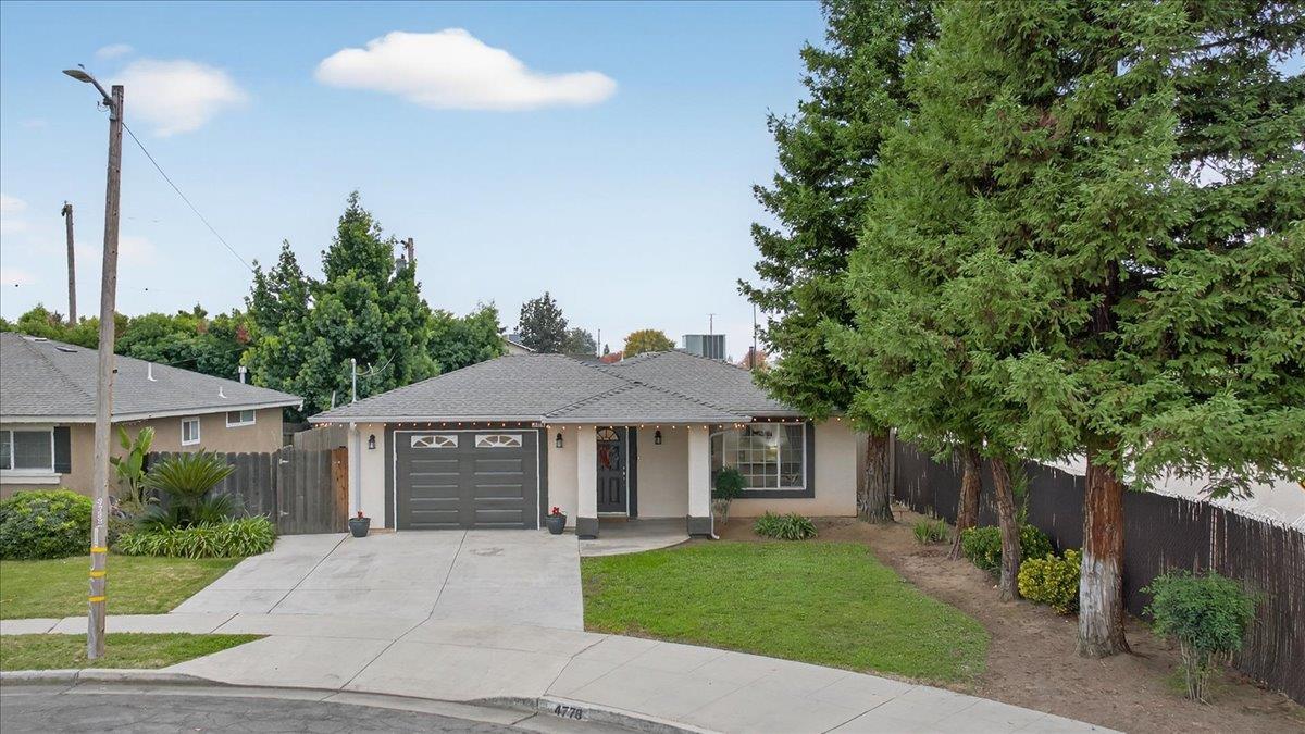 4776 East Rialto Avenue Fresno, CA 93726 - Photo 2 of 54 a front view of a house with a garden and tree