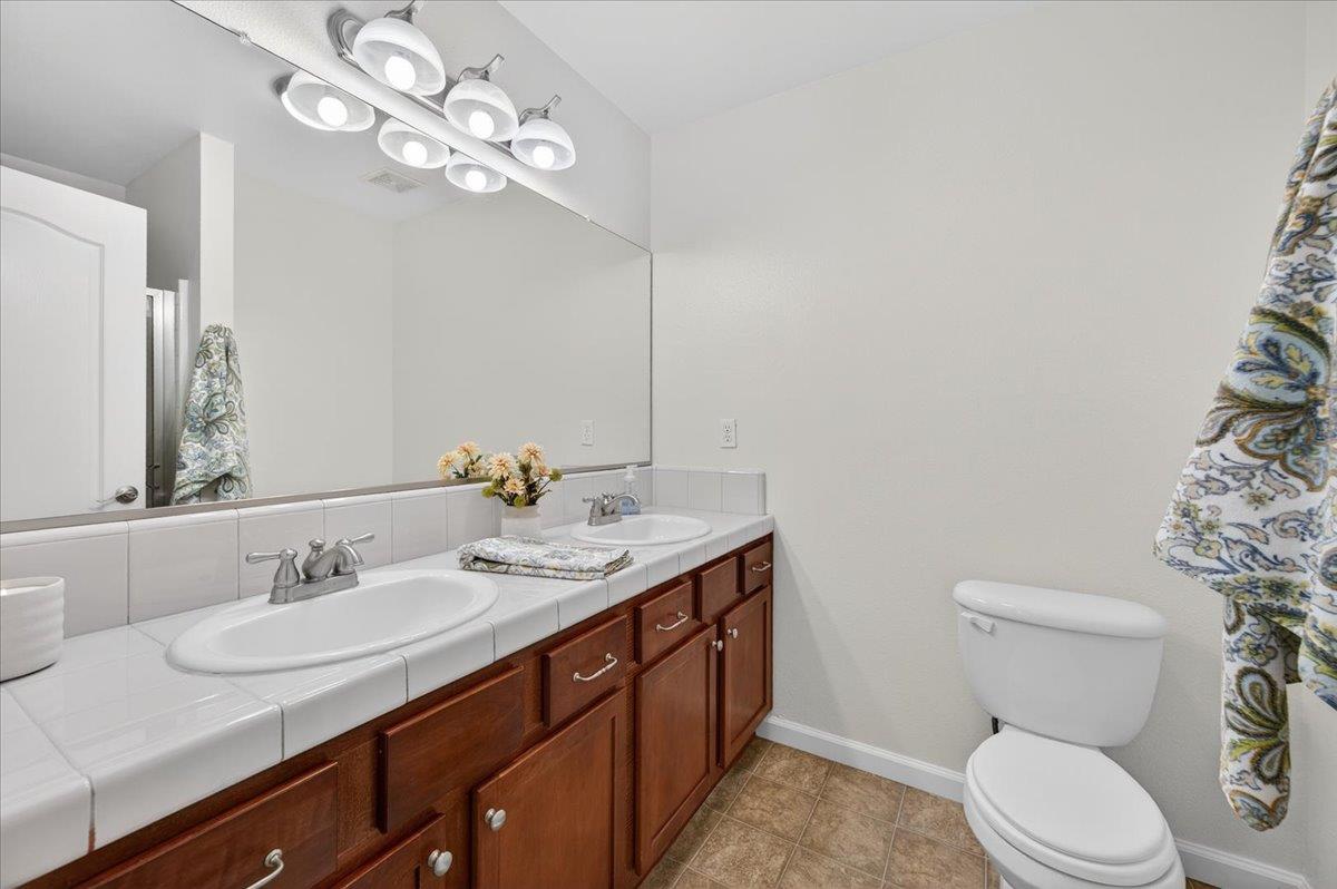 4776 East Rialto Avenue Fresno, CA 93726 - Photo 38 of 54 a bathroom with a granite countertop toilet sink and a mirror
