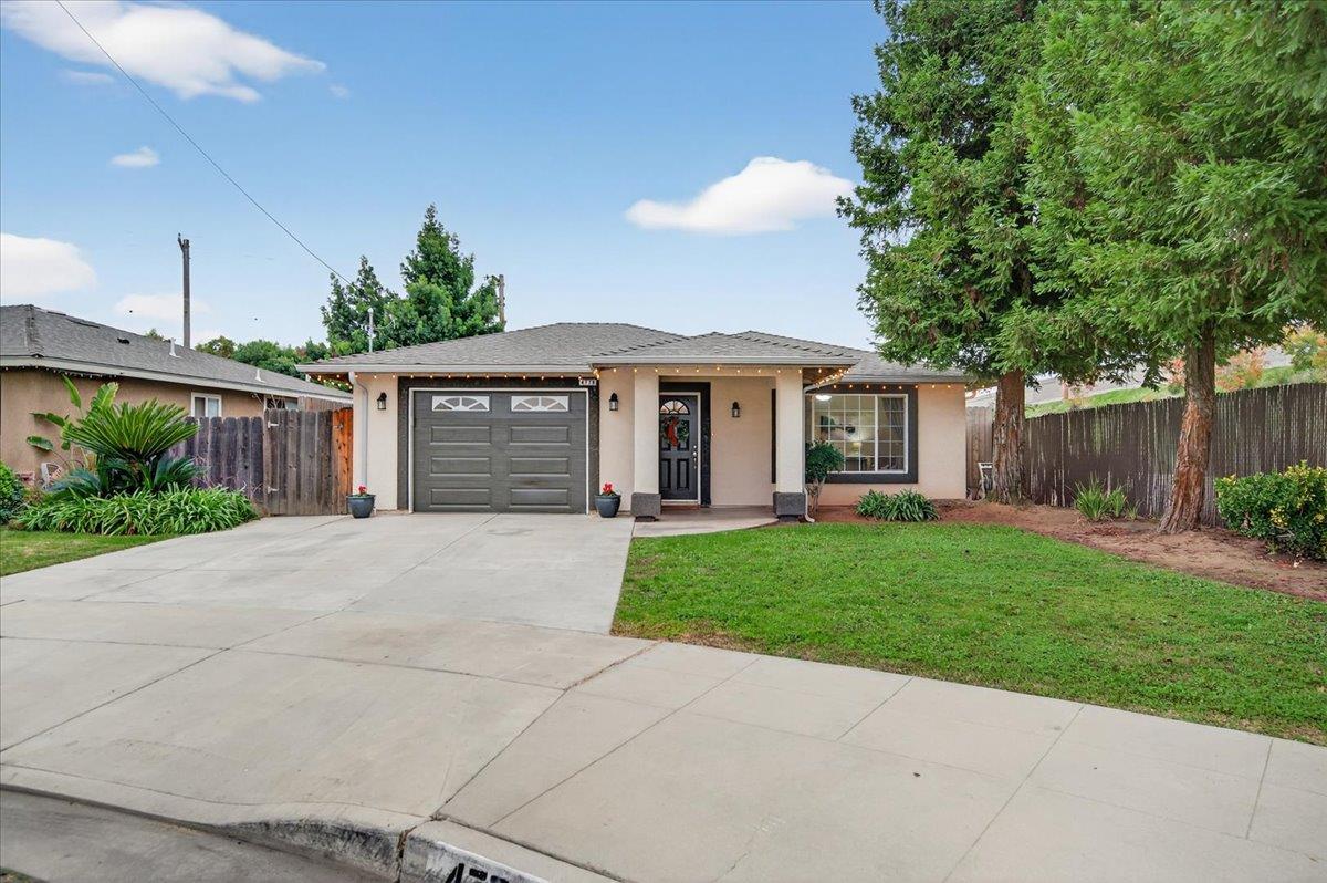 4776 East Rialto Avenue Fresno, CA 93726 - Photo 42 of 54 a front view of a house with a garden and trees