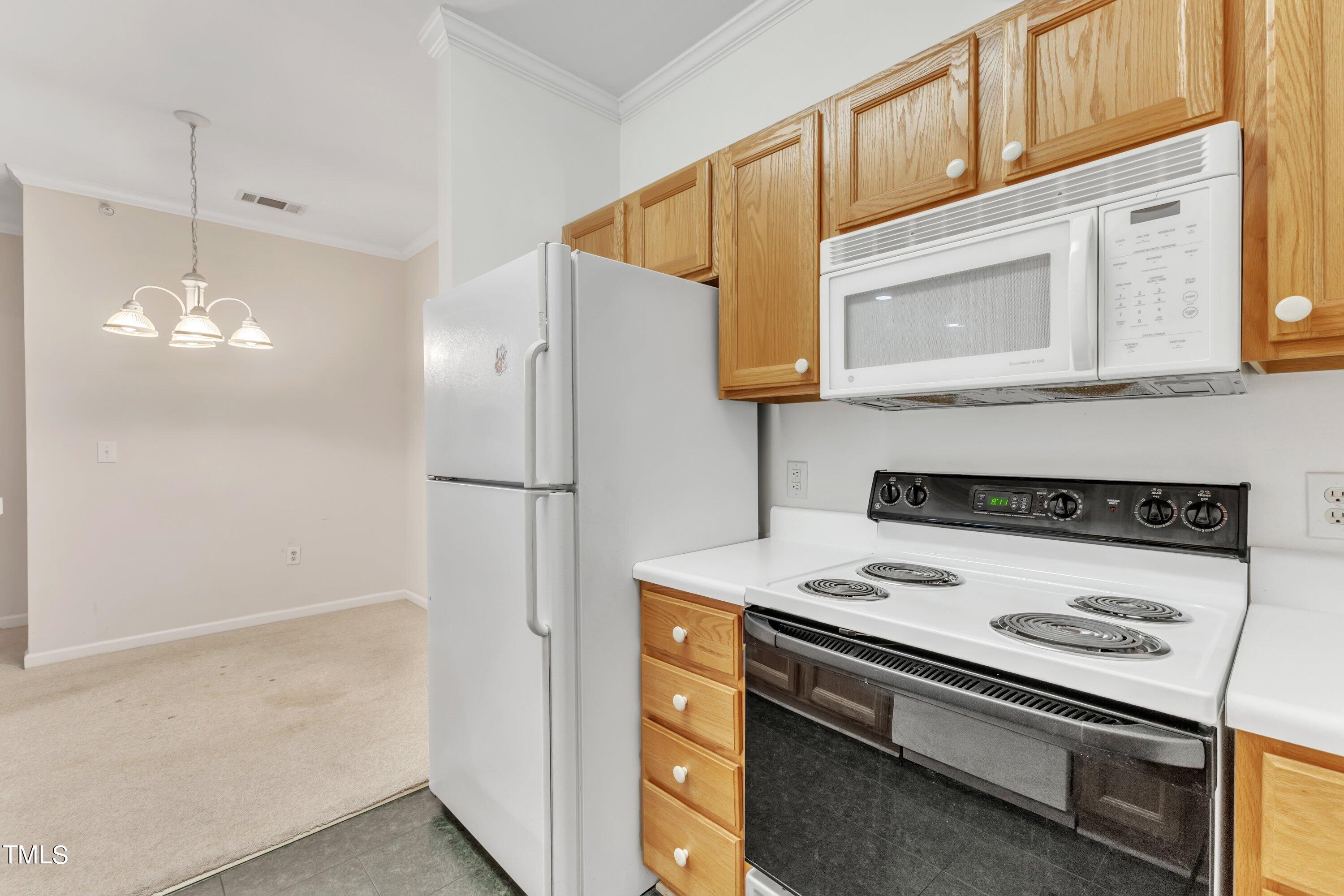 720 North Person Street, Unit 306 Raleigh, NC 27604 - Photo 6 of 13 a kitchen with stainless steel appliances granite countertop a refrigerator a stove and a microwave