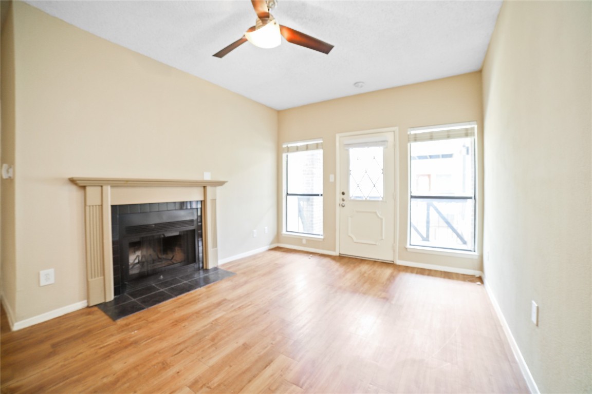 a view of an empty room with a fireplace and a window
