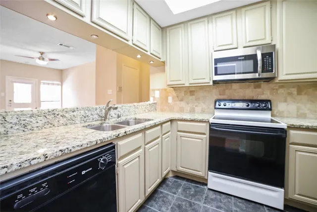 a kitchen with stainless steel appliances granite countertop a sink stove and cabinets
