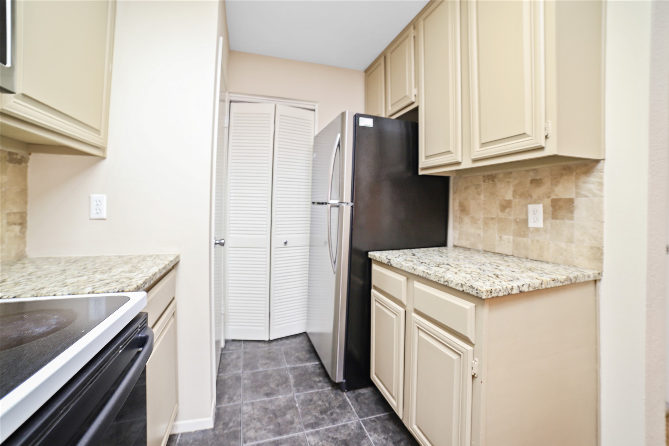 806 West 24th Street, Unit 220 Austin, TX 78705 - Photo 6 of 10 a kitchen with granite countertop a sink stove and refrigerator