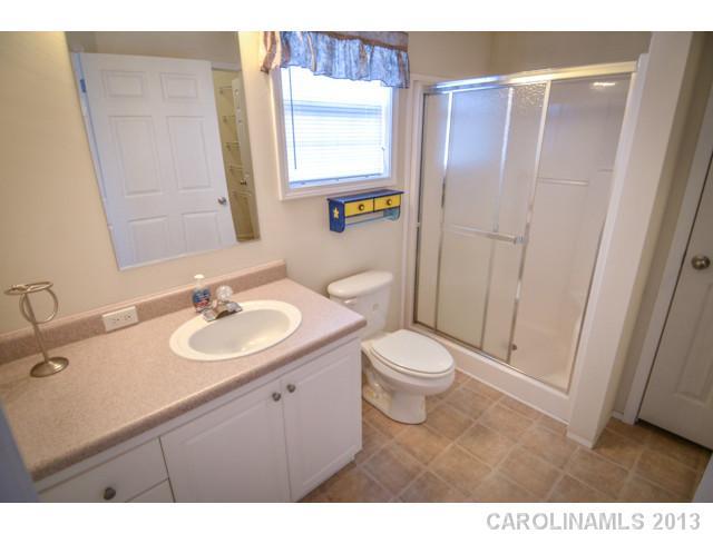 4520 Plyler Mill Road Monroe, NC 28112 - Photo 15 of 16 a bathroom with a sink a toilet a mirror and vanity