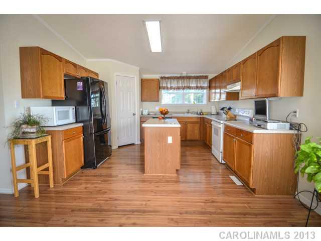 4520 Plyler Mill Road Monroe, NC 28112 - Photo 9 of 16 a kitchen with stainless steel appliances granite countertop a stove top oven a sink dishwasher and white cabinets with wooden floor