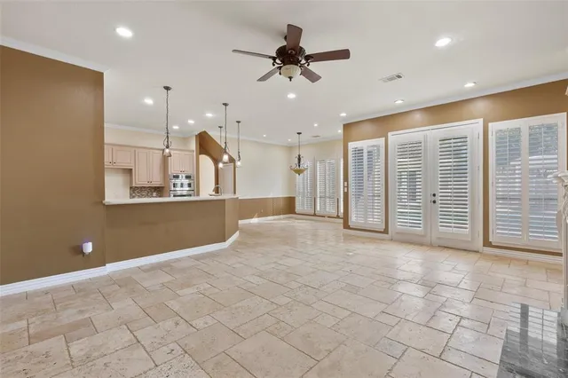 a view of a livingroom with a chandelier fan and windows