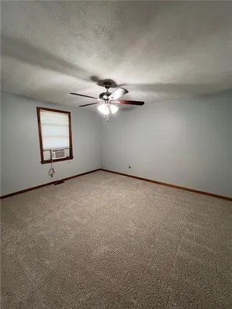an empty room with windows and ceiling fan