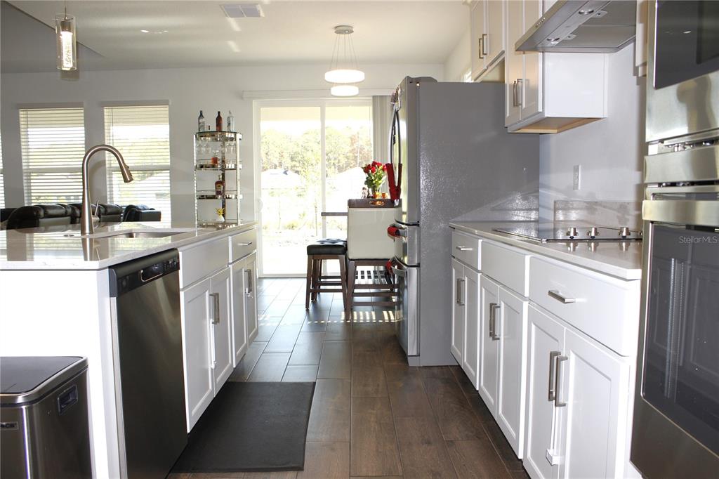 18331 Serene Lk Loop Lutz, FL 33548 - Photo 17 of 46 a kitchen with stainless steel appliances granite countertop a refrigerator oven a sink dishwasher and white cabinets with wooden floor