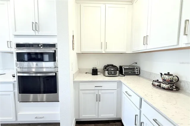a kitchen with granite countertop white cabinets and white appliances