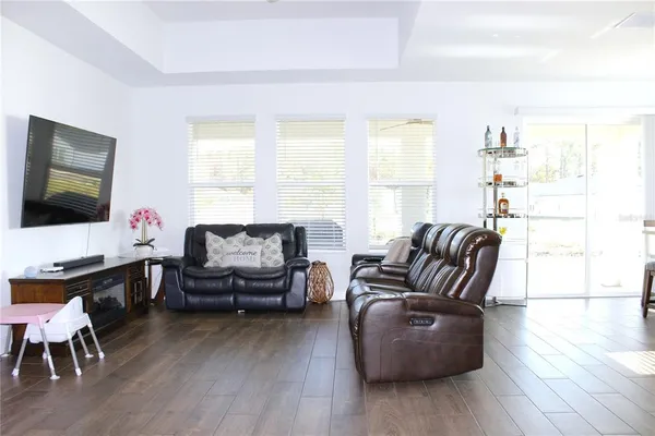 a living room with furniture flat screen tv and wooden floor