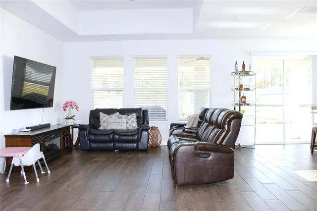 a living room with furniture flat screen tv and wooden floor