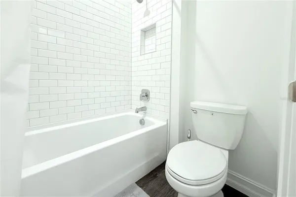 a white toilet sitting next to a bathtub