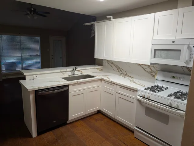 a utility room with granite countertop cabinets washer and dryer