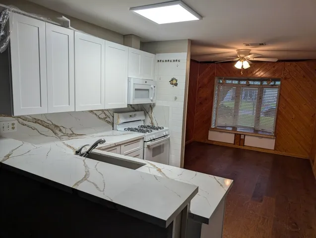a kitchen with a sink cabinets and wooden floor
