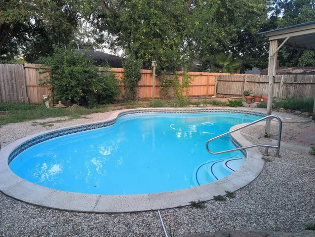 a view of a swimming pool with a yard