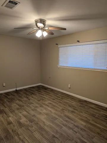a view of a room with wooden floor and chandelier fan