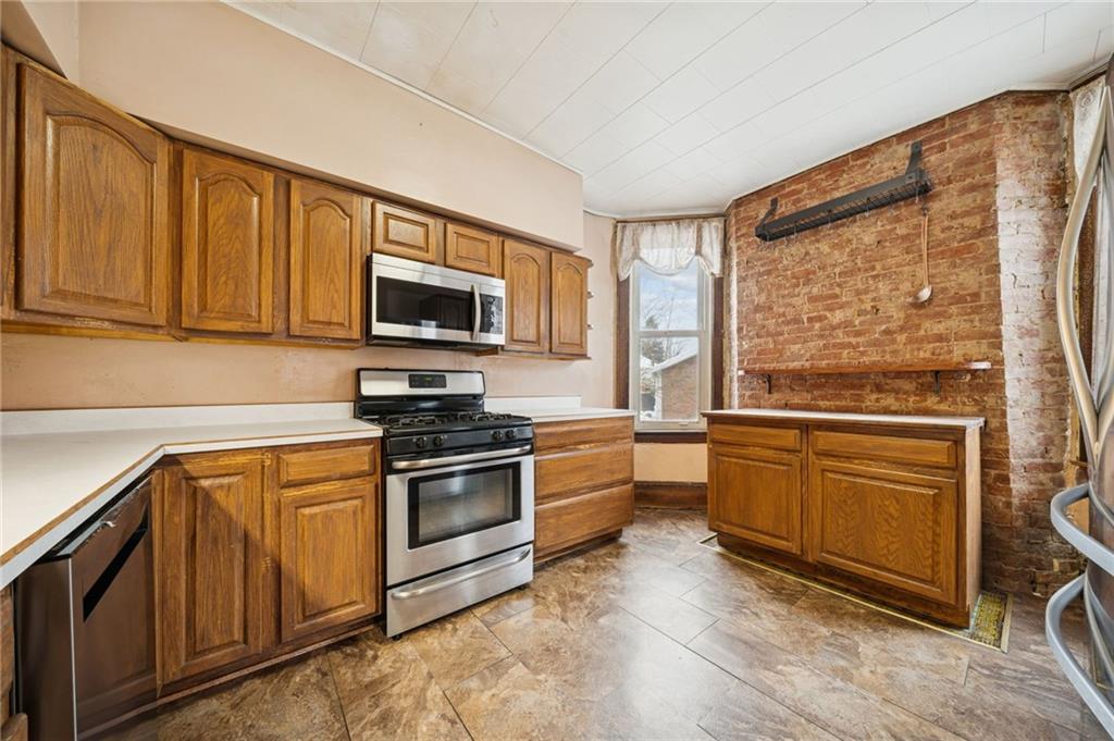 410 Point Street Saltsburg, PA 15681 - Photo 15 of 39 a kitchen with stainless steel appliances granite countertop a stove top oven a sink and dishwasher a refrigerator with wooden cabinets