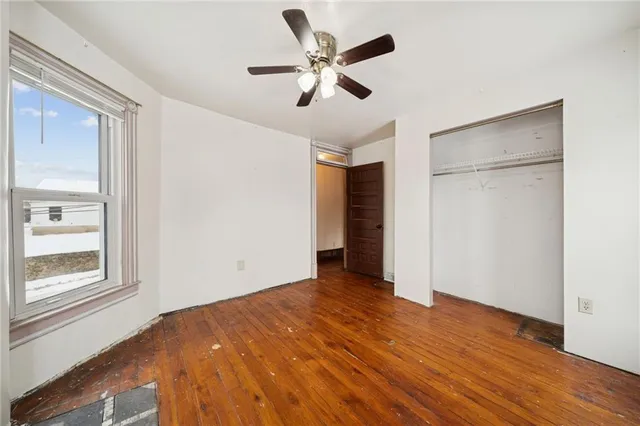an empty room with windows and closet