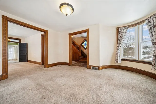 a view of a livingroom with a chandelier fan and windows