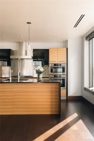 a kitchen with stainless steel appliances granite countertop a sink a stove and a refrigerator