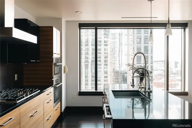 a view of a room with a large window and wooden floor