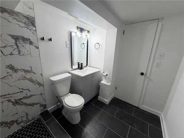 a white toilet sitting next to a bathroom sink