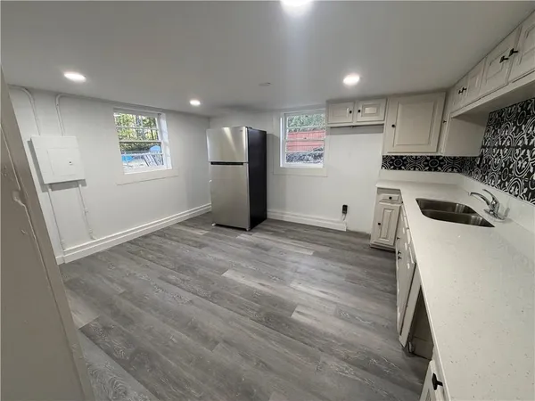a kitchen with granite countertop a sink and a refrigerator