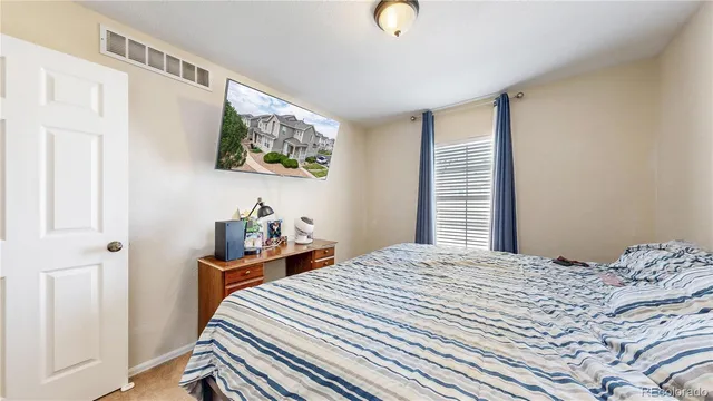 a bedroom with a bed and a painting on the wall