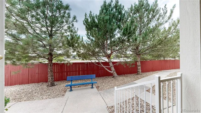 a view of backyard with wooden fence and a large tree