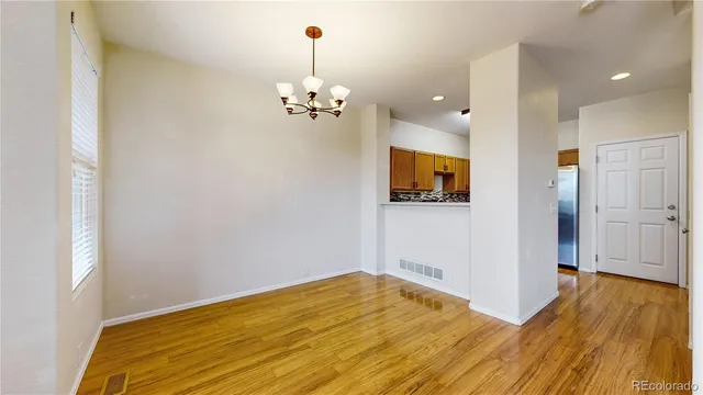a view of a room with wooden floor and chandelier