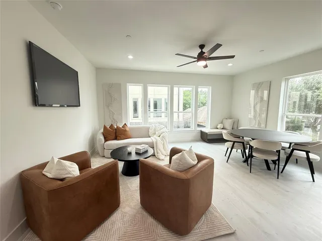 a living room with furniture ceiling fan and a flat screen tv