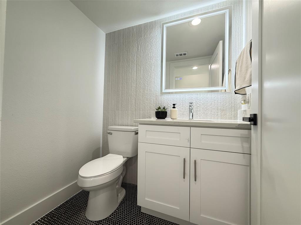 7207 Mohawk Drive, Unit 303 Dallas, TX 75235 - Photo 12 of 23 a bathroom with a toilet sink and mirror