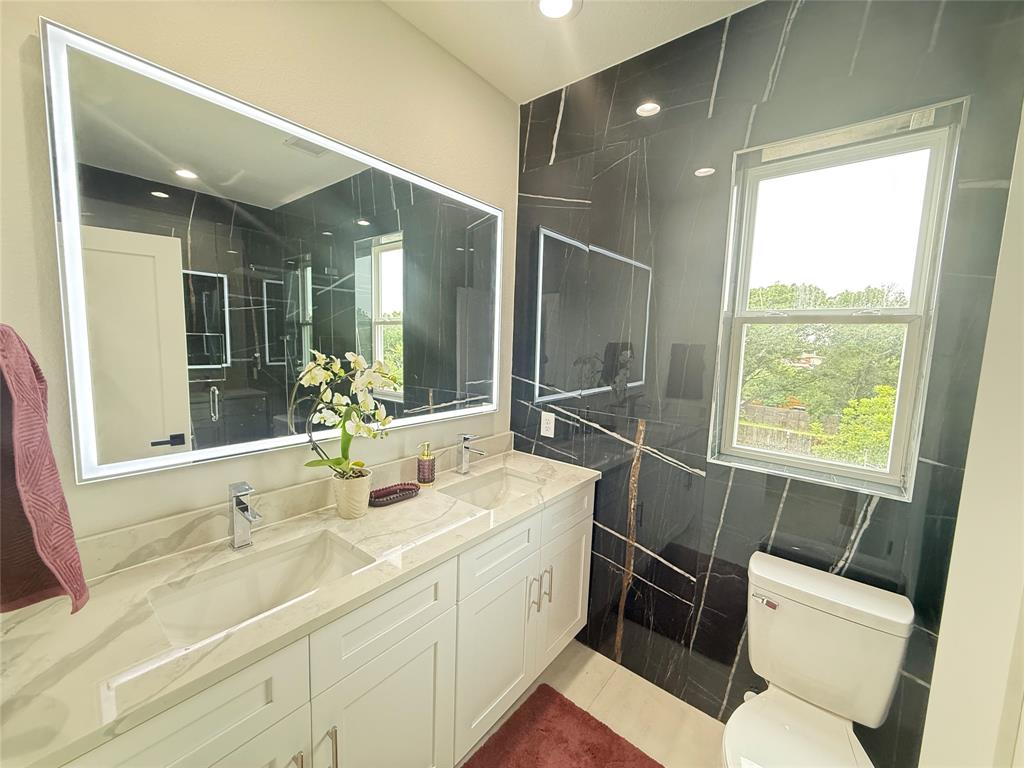 7207 Mohawk Drive, Unit 303 Dallas, TX 75235 - Photo 17 of 23 a bathroom with a double vanity sink toilet and a mirror