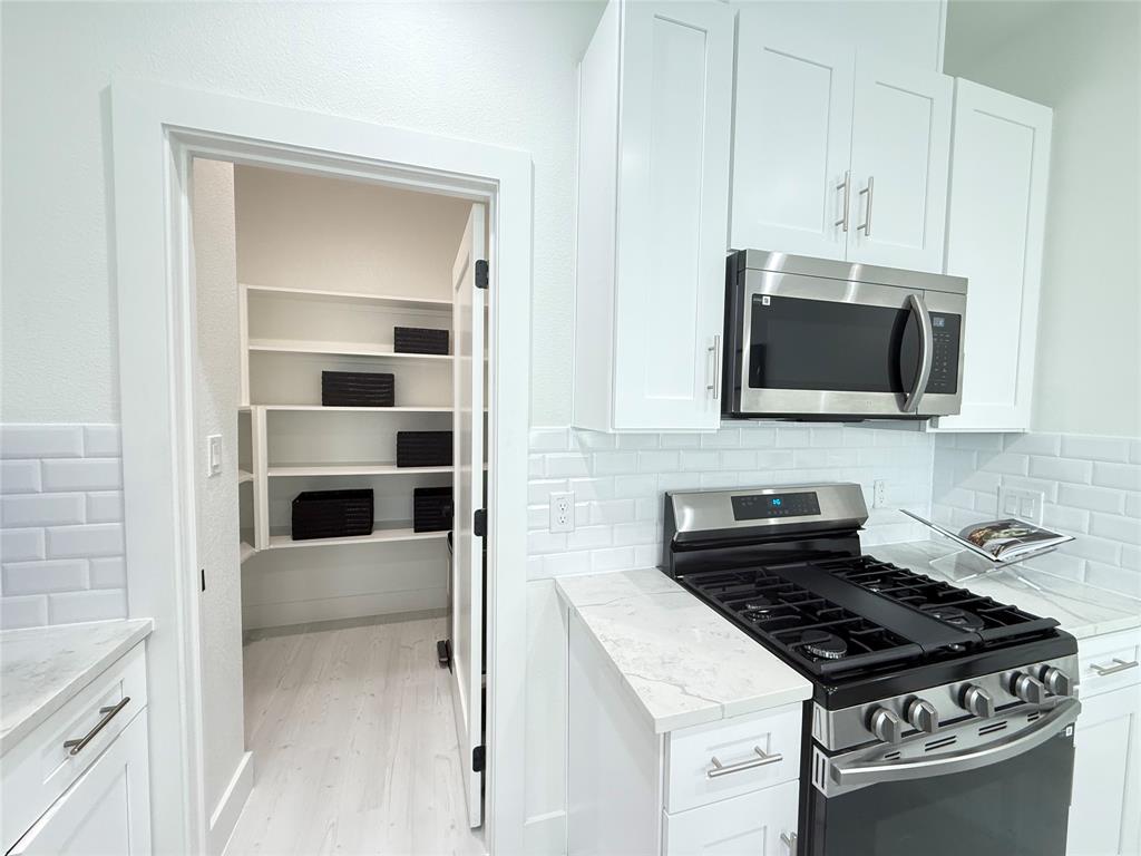 7207 Mohawk Drive, Unit 303 Dallas, TX 75235 - Photo 10 of 23 a kitchen with stainless steel appliances a stove and a microwave