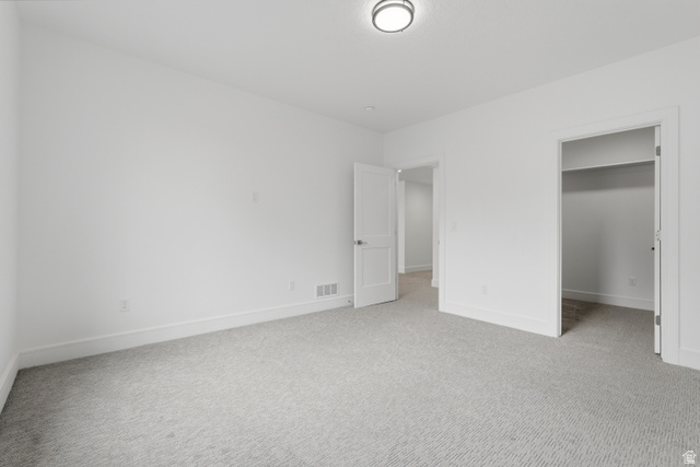 653 East Vandalay Lane Draper, UT 84020 - Photo 42 of 61 Spacious room featuring light gray patterned carpeting, crisp white walls, white baseboards, and a modern flush-mount ceiling light
