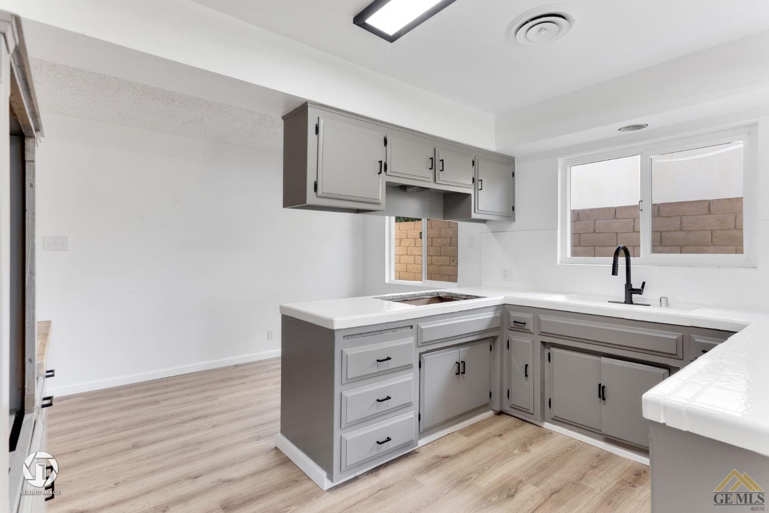 Undisclosed Address Bakersfield, CA 93308 - Photo 11 of 27 a kitchen with a sink stove and cabinets