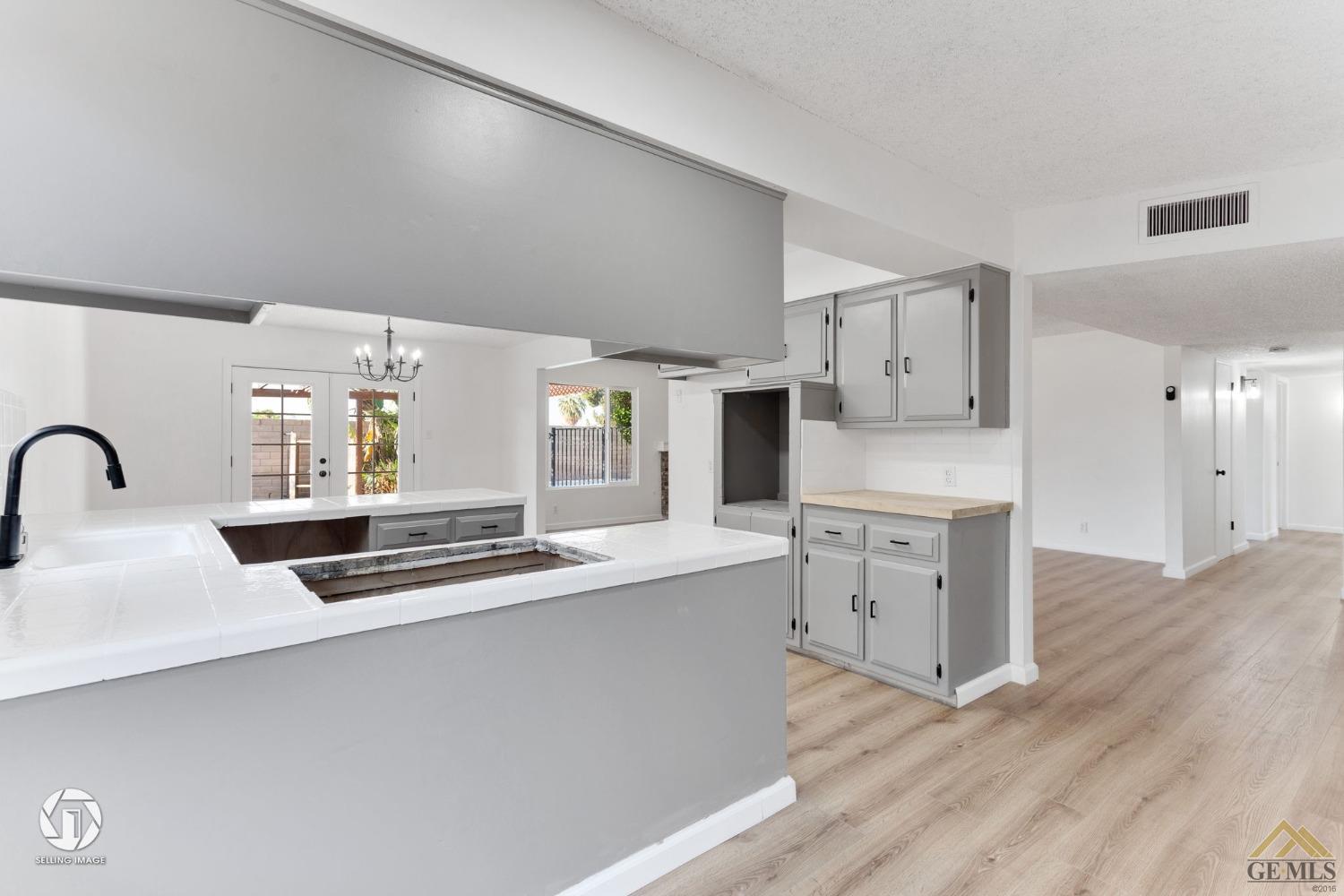 Undisclosed Address Bakersfield, CA 93308 - Photo 9 of 27 a kitchen with white cabinets and appliances