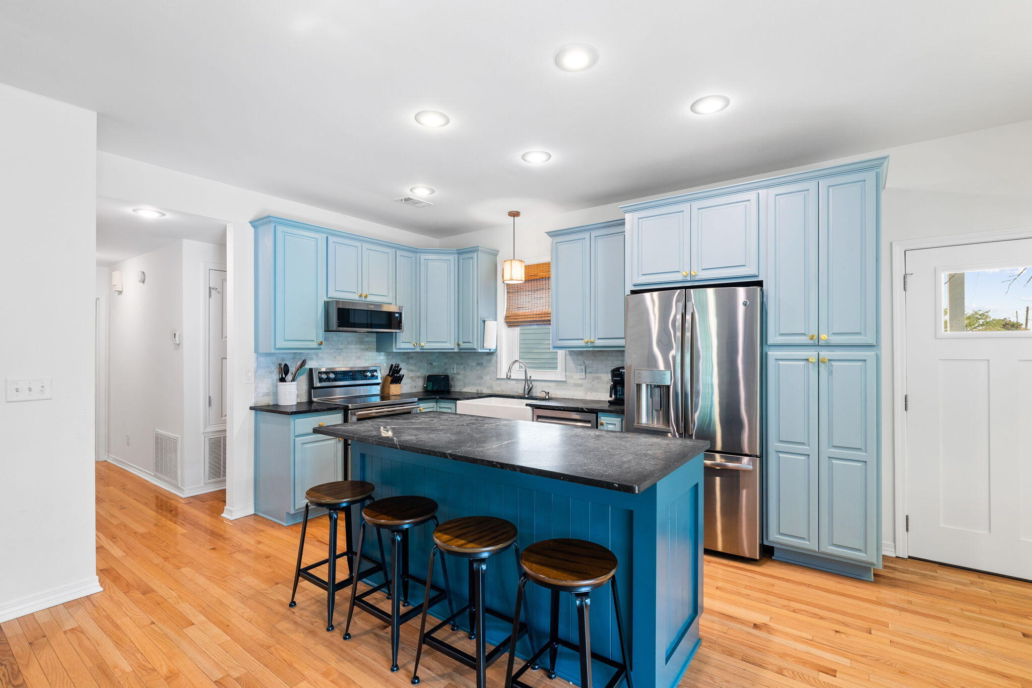 85 Dolphin Street Destin, FL 32541 - Photo 22 of 63 a kitchen with stainless steel appliances granite countertop a refrigerator a stove a sink dishwasher a dining table and chairs with wooden floor
