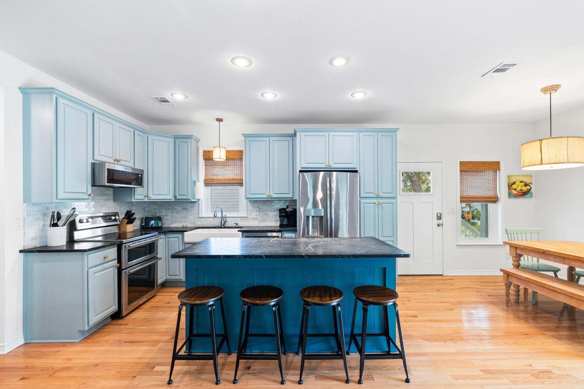 85 Dolphin Street Destin, FL 32541 - Photo 3 of 63 a kitchen with stainless steel appliances granite countertop a stove top oven a refrigerator a sink and a dining table with wooden floor