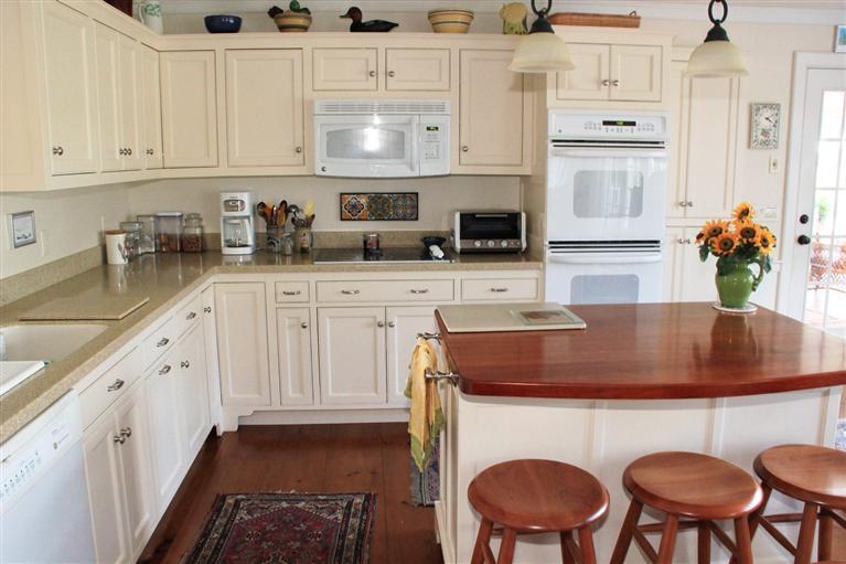 46 Lookout Road Yarmouth Port, MA 02675 - Photo 17 of 35 a kitchen with stainless steel appliances granite countertop a stove a sink dishwasher and white cabinets with wooden floor