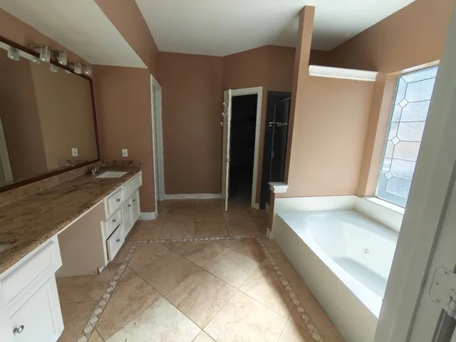 a spacious bathroom with a granite countertop sink and a large mirror