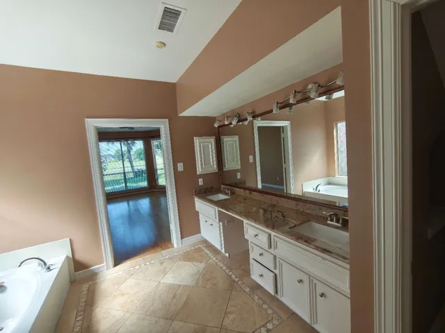 a bathroom with a granite countertop sink and a mirror