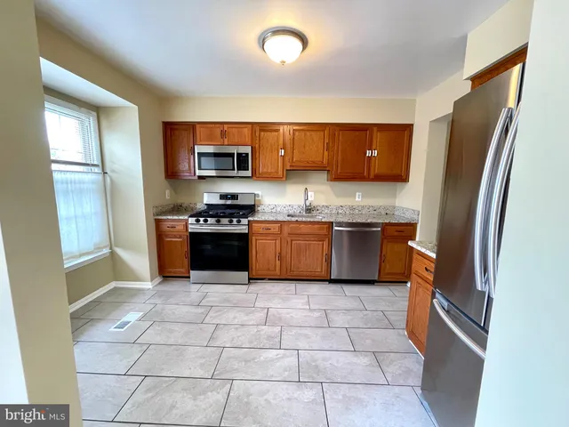 a kitchen with stainless steel appliances granite countertop a refrigerator and a sink