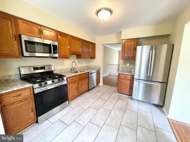 a kitchen with stainless steel appliances granite countertop a refrigerator stove top oven and sink