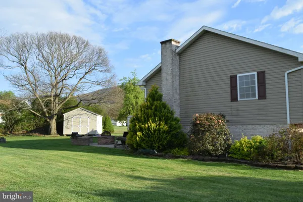 a front view of a house with a garden and trees