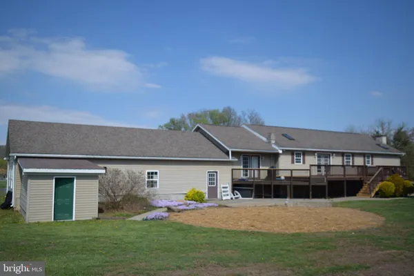 a front view of a house with a yard and trees