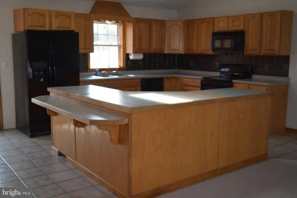 a kitchen with stainless steel appliances granite countertop a refrigerator a stove a sink and a microwave