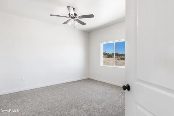 a view of a room with a ceiling fan and a window