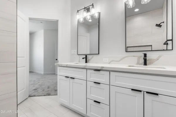 a bathroom with double sink and a mirror